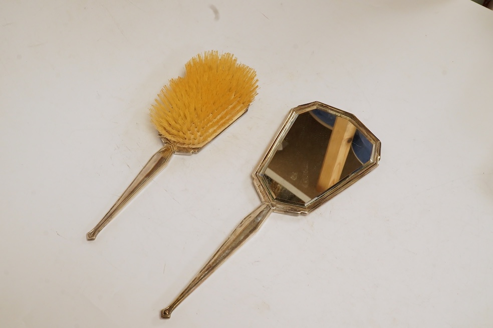 A cased George VI Art Deco silver mounted silver four piece mirror, brush and comb set, Charles S. Green & Co, Birmingham, 1948-1952. Condition - poor to fair to good.